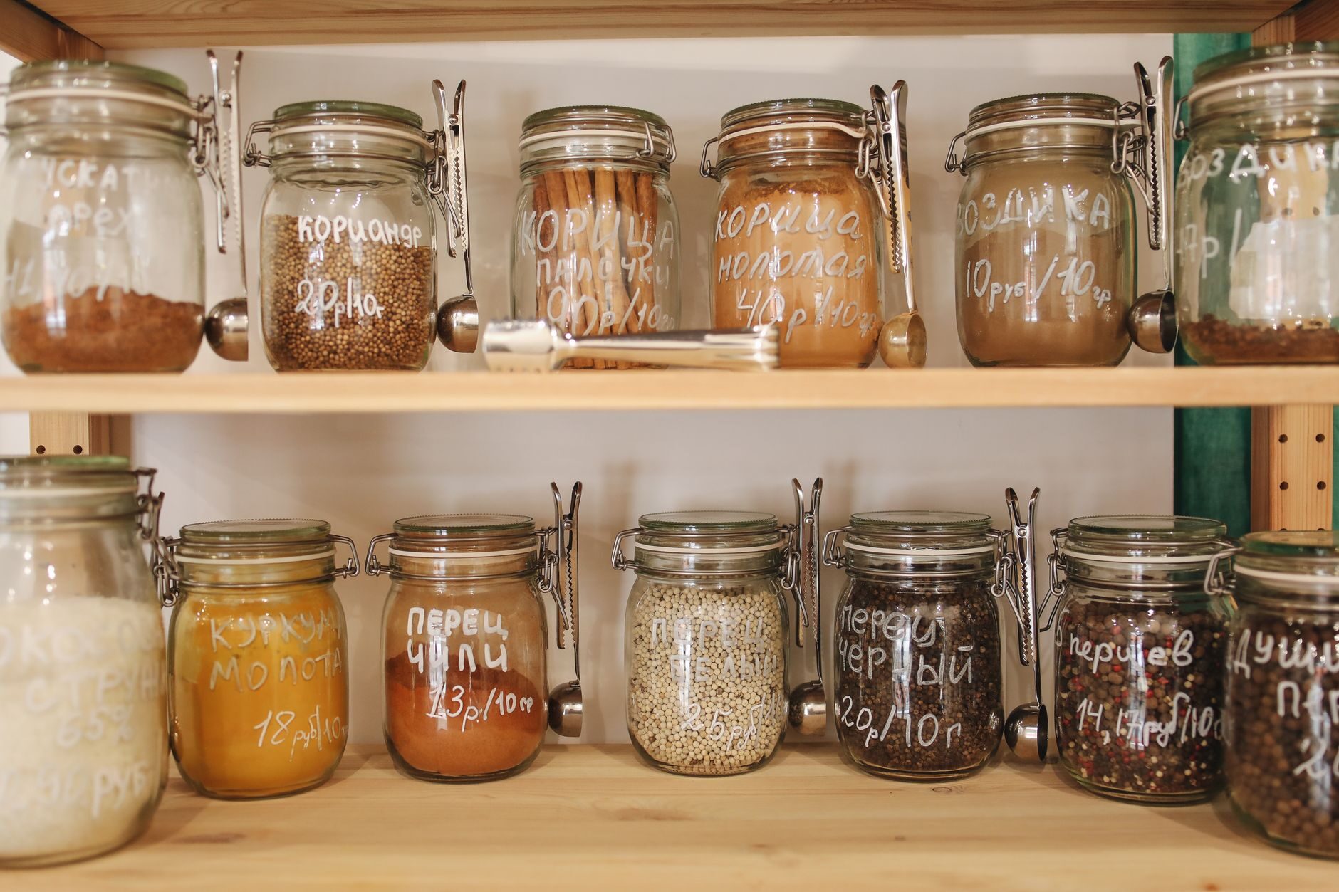 Organized kitchen pantry with labelled glass jars on open shelving
